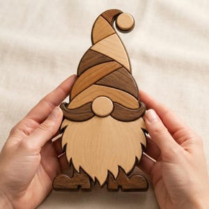 May include: A wooden gnome figurine crafted from multiple pieces of light and dark wood. The gnome features a tall, curved hat, a round nose, a wide mustache, and a long, pointed beard, all assembled with visible seams between the wood segments.