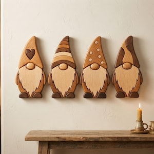 Op de afbeelding: Vier aan de muur gemonteerde houten kabouterfiguren op een rij. Elke kabouter heeft een uniek hoedontwerp: één met een hartje, één met horizontale strepen, één met stippen en één met een abstract patroon, allemaal in tinten van licht en donker hout.
