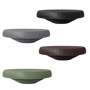 May include: A set of four circular wall hooks with a textured, matte finish. The hooks are arranged vertically and feature distinct colours: black, dark grey, dark brown, and muted olive green. Each hook has a flat top surface and a tapered base.