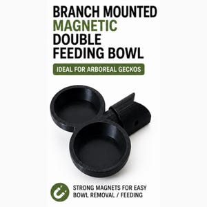 May include: A black plastic double feeding bowl with a magnetic mounting mechanism. The text reads: BRANCH MOUNTED MAGNETIC DOUBLE FEEDING BOWL, IDEAL FOR ARBOREAL GECKOS, and STRONG MAGNETS FOR EASY BOWL REMOVAL / FEEDING. The design features two circular basins.