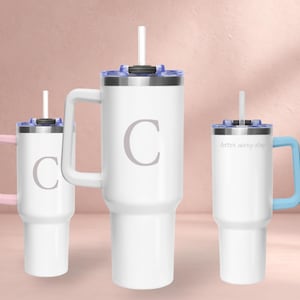 Puede incluir: Vasos aislados blancos con asas y pajitas. Uno tiene un asa rosa, otro un asa azul y el más grande un asa blanca. Los vasos tienen tapas plateadas y la letra "C" o la frase "better every day" impresa.