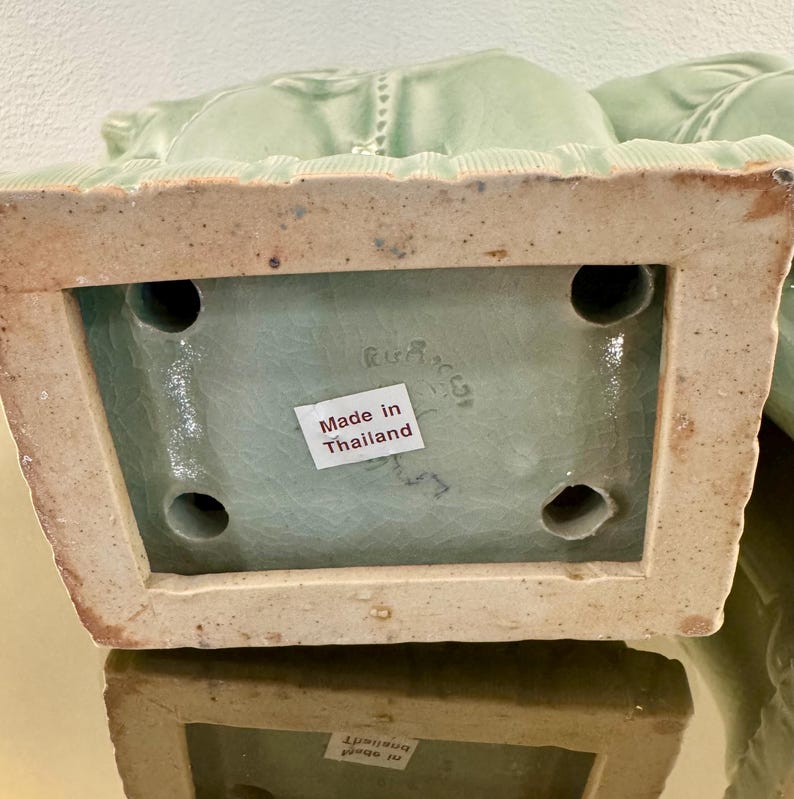 May include: A light green ceramic base with a crackle glaze finish, featuring a rectangular shape with four circular openings on the underside. A white sticker with the text Made in Thailand is affixed to the center of the base surface.