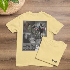 May include: A light yellow t-shirt with a photo collage and text that reads "Thanks for being my Mom, Love, Your Favorite Child." A second t-shirt is folded next to it with the word "NAME" printed on it. The shirts are on a wooden surface.