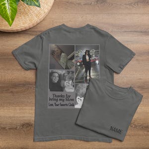 May include: Gray t-shirt with a collage of photos and the text "Thanks for being my Mom, Love, Your Favorite Child." A second t-shirt is folded next to it, with the word "NAME" printed on it. The shirts are on a wooden surface.