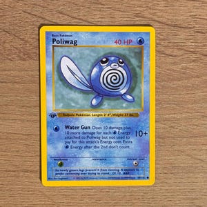 May include: A blue Poliwag trading card featuring a round, blue tadpole character with a white spiral on its belly and a long tail. The card displays 40 HP, the Water Gun attack text, and details including a length of 2' 0" and weight of 27 lbs.