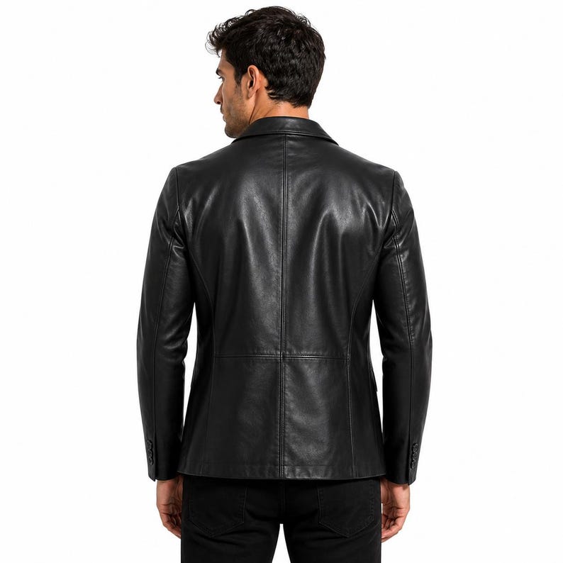 May include: Black leather blazer with a notched lapel and buttoned cuffs. The jacket has a classic, tailored fit and a smooth, matte finish. The back view showcases the jacket's clean lines and structured design.
