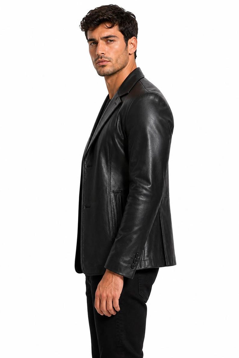May include: A black leather blazer with a notched lapel and two-button closure. The blazer has a tailored fit and features three buttons on each cuff. The garment is worn over a black shirt and black pants.