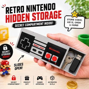 May include: A gray and black plastic storage box shaped like a retro Nintendo game controller. The controller features a D-pad, Select and Start buttons, and red A and B buttons. The unit slides open to reveal a secret compartment containing a key and USB drive.