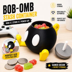 May include: A black spherical stash container with white oval eyes and yellow feet, resembling a Bob-omb character. It includes a grey circular lid with a white stem, filled with colourful gummy sweets, alongside silver coins on the surface.