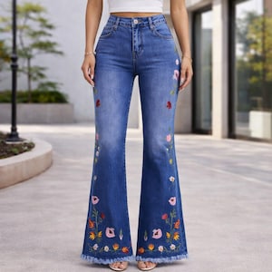 Könnte beinhalten: Blaue Schlaghose aus Jeansstoff mit farbenfrohen Blumenstickereien. Die Jeans hat eine hohe Taille, ein klassisches Fünf-Taschen-Design und einen ausgefransten Saum. Die gestickten Blumen umfassen rosa, rote, orange und gelbe Blüten.