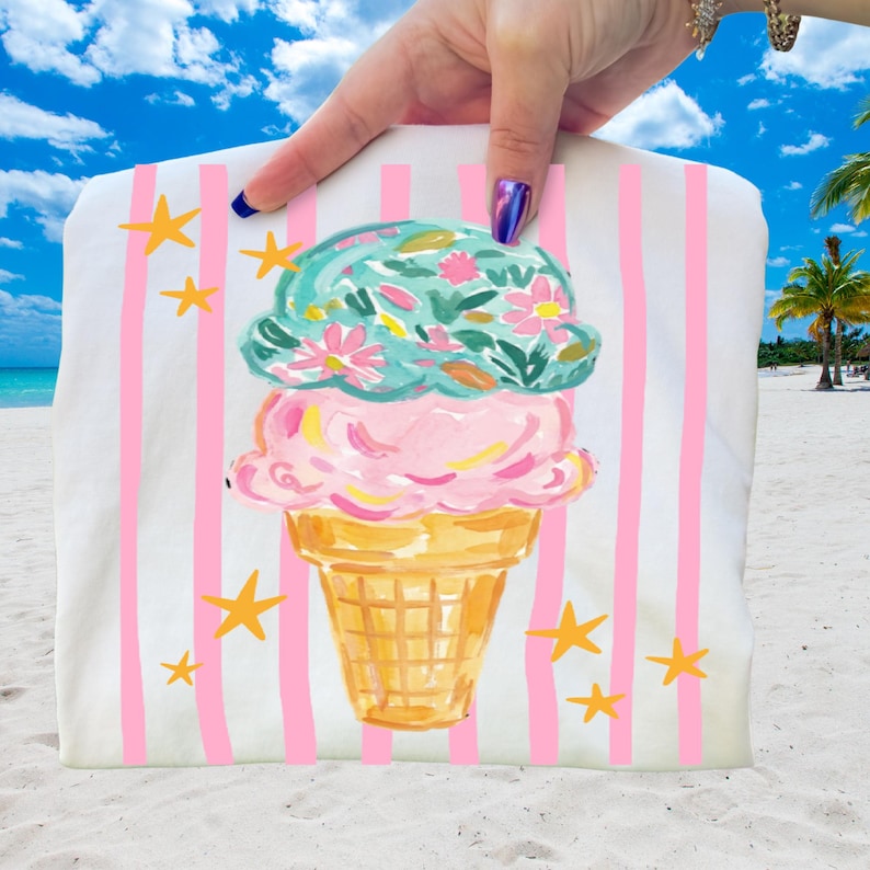 Retro pastel striped png featuring double scoop pastel ice cream cone top scoop has floral pattern and bottom scoop is pink.  Background stripes are pink yellow stars scattered.   Shown here on a folded white tee.