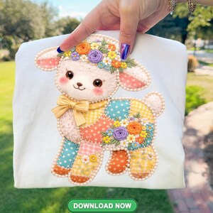 May include: White t-shirt with a charming lamb design. The lamb is adorned with a floral crown, a yellow bow, and a patchwork body with colorful floral details. The image includes the text "DOWNLOAD NOW".