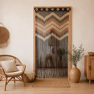 May include: A wooden beaded door curtain with a chevron pattern in black, tan, and brown. The curtain hangs in a wooden door frame. The room has a bohemian style with a wicker chair, a woven wall hanging, and a jute rug.