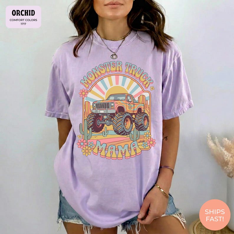 Comfort Colors graphic tee featuring a retro groovy monster truck with floral details, desert cacti, and a sunburst backdrop, arched text reading Monster Truck Mama, designed for moms of boys, Monster Jam fans, and birthday party season.