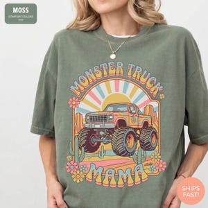 Comfort Colors graphic tee featuring a retro groovy monster truck with floral details, desert cacti, and a sunburst backdrop, arched text reading Monster Truck Mama, designed for moms of boys, Monster Jam fans, and birthday party season.