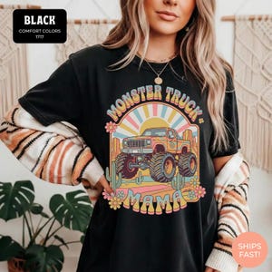 Comfort Colors graphic tee featuring a retro groovy monster truck with floral details, desert cacti, and a sunburst backdrop, arched text reading Monster Truck Mama, designed for moms of boys, Monster Jam fans, and birthday party season.