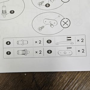 May include: Diagram of furniture assembly instructions. Includes illustrations of screws, handles, and other hardware components. The diagram shows how to correctly and incorrectly install a component, with a check mark and an X symbol.