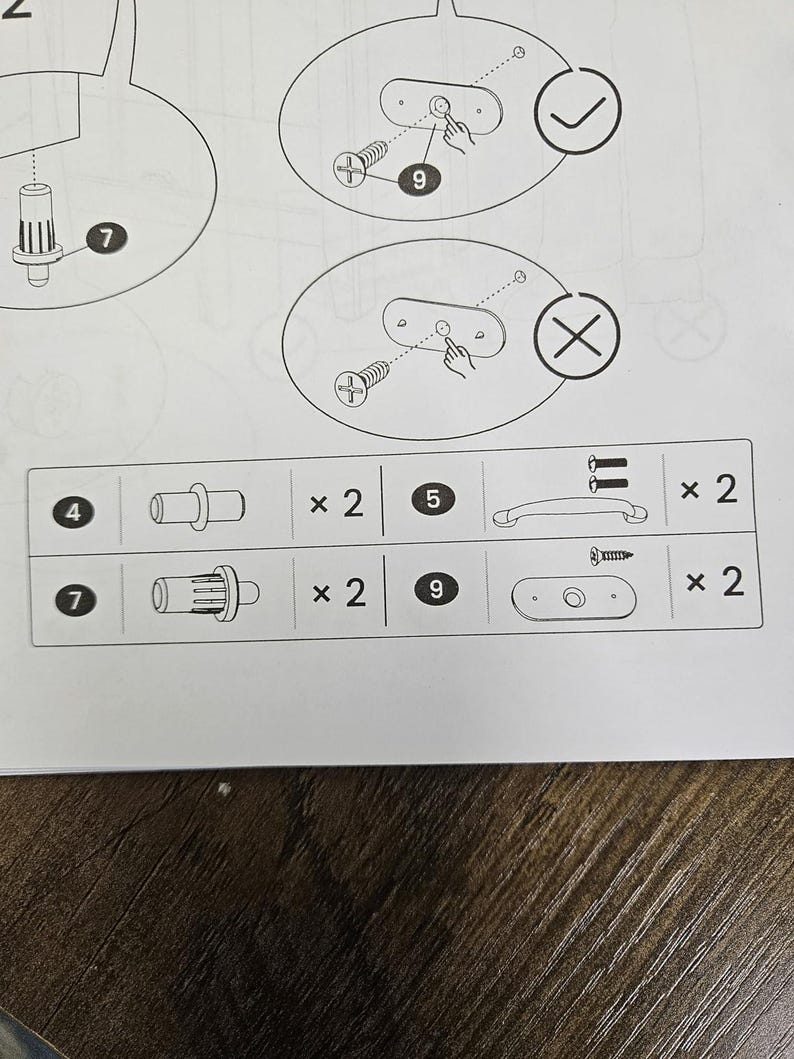 May include: Diagram of furniture assembly instructions. Includes illustrations of screws, handles, and other hardware components. The diagram shows how to correctly and incorrectly install a component, with a check mark and an X symbol.