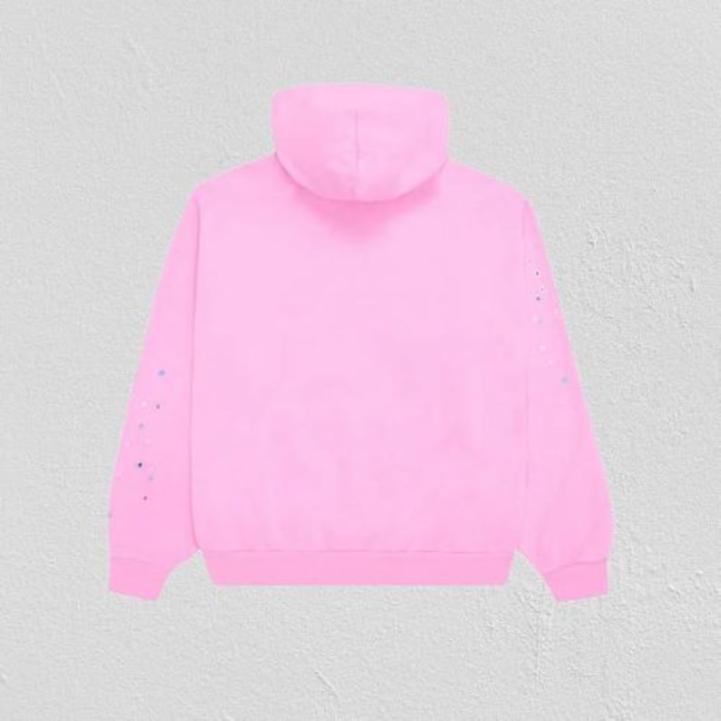 K&ouml;nnte beinhalten: Ein hellrosa Kapuzenpullover mit Kordelzug und langen &Auml;rmeln. Die &Auml;rmel sind mit kleinen, bunten Farbspritzern verziert. Der Hoodie besteht aus einem weichen Material und ist f&uuml;r den Alltag geeignet.