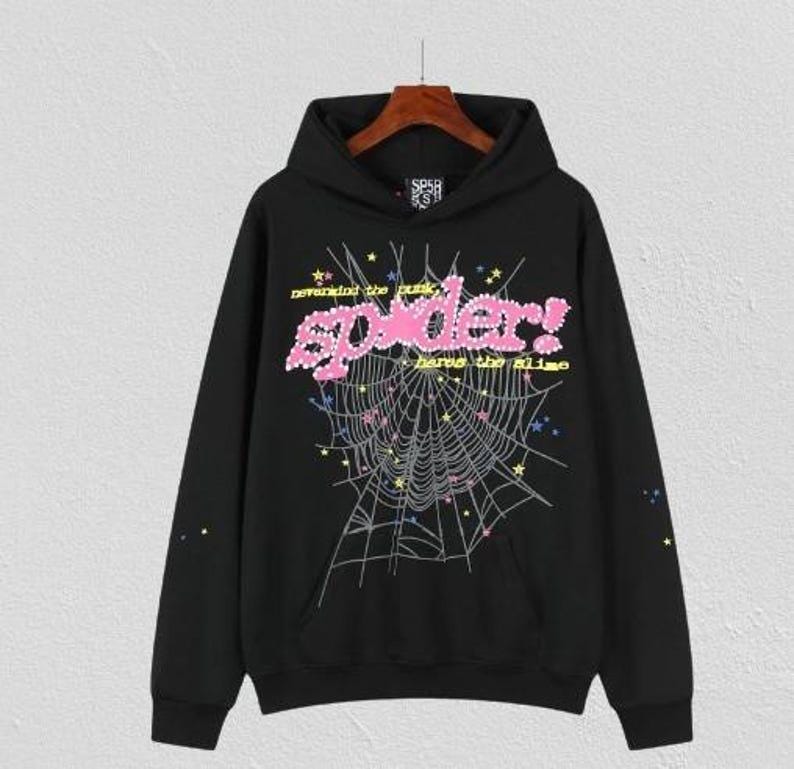 Puede incluir: Sudadera con capucha negra con un dise&ntilde;o de telara&ntilde;a y la palabra "spider!" en letras rosas con burbujas. Tambi&eacute;n es visible el texto "nevermind the punk, have the slime". La sudadera tiene un bolsillo delantero y una capucha con cord&oacute;n.