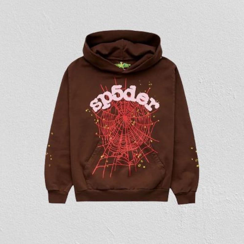 K&ouml;nnte beinhalten: Brauner Kapuzenpullover mit Fronttasche und Kapuze. Auf der Vorderseite befindet sich ein rotes Spinnennetz-Design mit dem Wort "sp5der" in Rosa. Kleine gelbe Sternakzente sind verstreut.