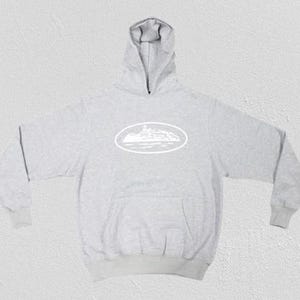 Op de afbeelding: Een lichtgrijze hoodie met een witte ovale afbeelding op de voorkant. De hoodie heeft een capuchon, lange mouwen en een voorzak. De afbeelding lijkt een landschap te zijn.