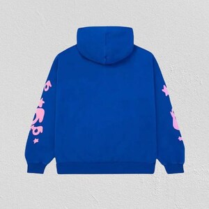 K&ouml;nnte beinhalten: Ein k&ouml;nigsblauer Kapuzenpullover mit Kapuze und langen &Auml;rmeln. Die &Auml;rmel zeigen rosa Text und Sterngrafiken. Der Hoodie ist aus einem weichen Material gefertigt und eignet sich f&uuml;r Freizeitkleidung.