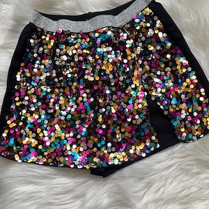 May include: Black shorts with a silver waistband and colorful sequins.