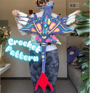 May include: A colorful crochet dragon with blue, yellow, pink, and white accents. The dragon has large wings and a long tail with a red tip. The text "Crochet Pattern" is displayed in a glowing font.