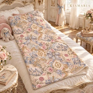 May include: A rectangular quilt featuring a repeating pattern of light blue bows, pink roses, white floral clusters, gold filigree, castle illustrations, and wax-sealed envelopes on a cream background, with a solid white underside.
