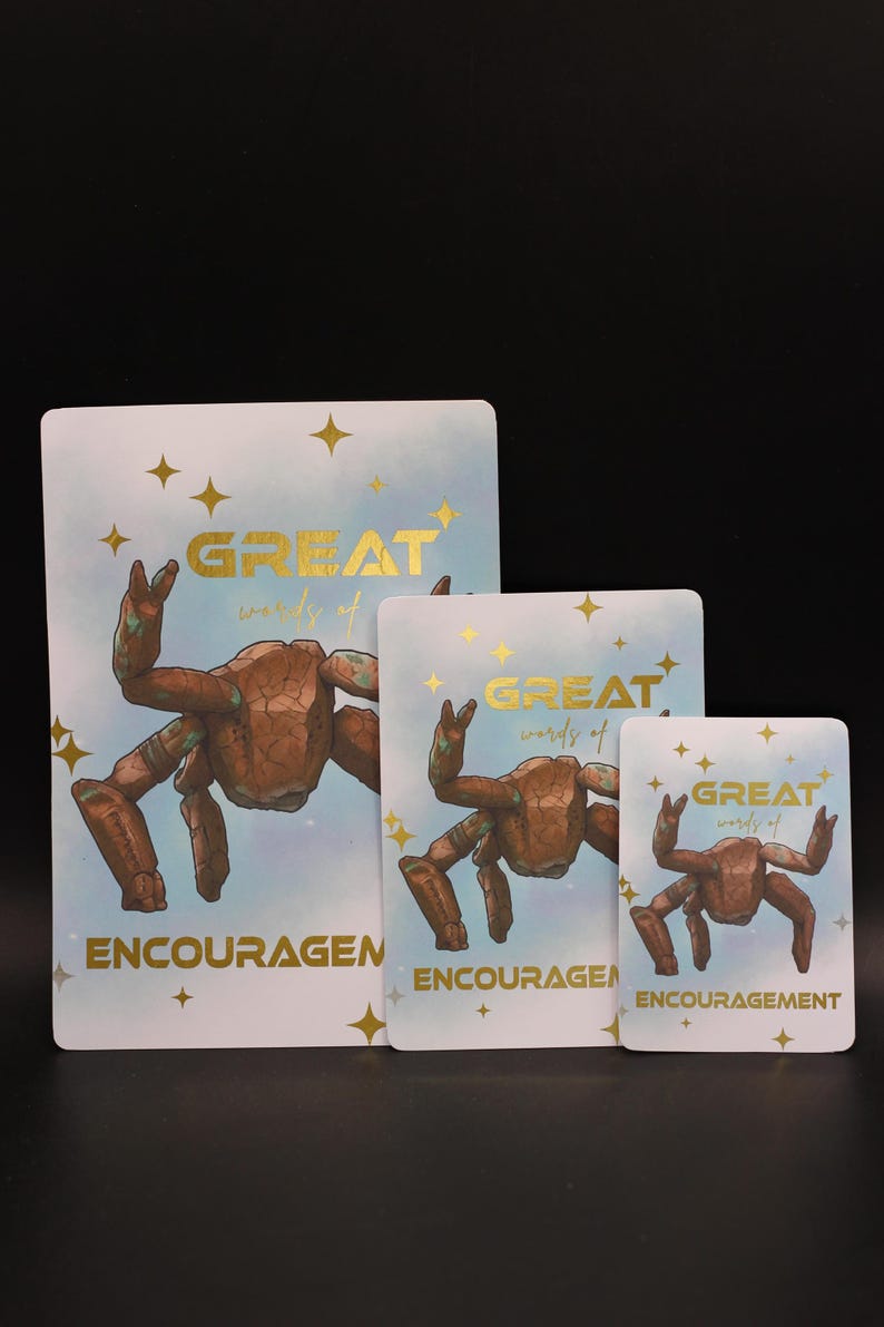 May include: Three rectangular cards of varying sizes featuring a brown rock-like crab illustration on a light blue background with gold stars. The text reads "GREAT words of ENCOURAGEMENT" in gold lettering across the center and bottom of each card.