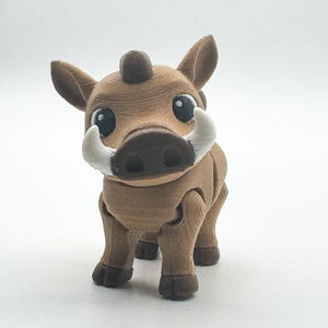 Könnte beinhalten: Eine braune, 3D-gedruckte Warzenschwein-Figur mit großen weißen Stoßzähnen, großen schwarzen Augen und einem kleinen, abgerundeten Horn. Die Figur hat bewegliche Gelenke und steht auf vier Beinen. Der Hintergrund ist weiß.