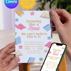 Może przedstawiać: Jasnoniebieska karta zaproszenia z tekstem "Growing like a Read" i "We can't believe Ella is 2!" jest trzymana w rękach osoby. Karta ma ilustracje książek i kwiatów. Telefon wyświetla to samo zaproszenie.
