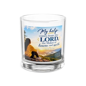 May include: A clear glass tumbler featuring a printed graphic of a person sitting on a rock overlooking a mountain landscape at sunrise. The text reads: My help comes from the LORD, the Maker of heaven and earth. Psalms 121:2 NIV. The One who created it all cares for you.