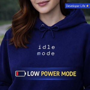 Op de afbeelding: Een witte keramische mok met een zwarte handgreep en de tekst "But First, Coffee" in een vetgedrukte, zwarte letter. De mok staat tegen een vage achtergrond. De mok is ongeveer 10 cm hoog.