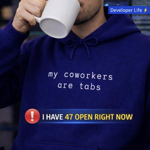 May include: A navy blue hoodie with the text "my coworkers are tabs" in white. Below the text is a banner that says "I HAVE 47 OPEN RIGHT NOW." The upper right corner has the text "Developer Life." A person is holding a white mug.