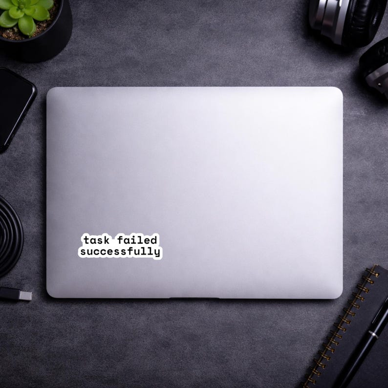 May include: A white ceramic mug with a black handle and the text "But First, Coffee" in a black, handwritten-style font. The mug is on a white surface.