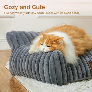 May include: A grey, corduroy-textured pet bed with an orange and white cat resting on it. The bed has a rectangular shape with a raised back and sides. The image includes the text "Cozy and Cute".