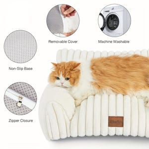 May include: A cream-coloured pet bed with a corduroy texture, featuring a non-slip base and a removable cover. An orange and white cat is resting on the bed. The bed has a zip closure and is machine washable.