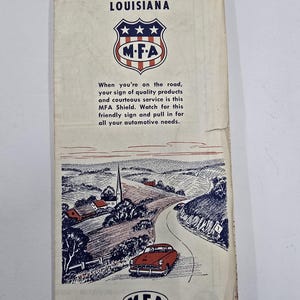 May include: Vintage road map of Arkansas and Louisiana from the MFA Oil Company. The map features a red car driving on a winding road, with illustrations of a church and rural landscape. The cover includes the MFA logo and text promoting their services.