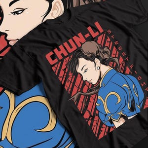 Op de afbeelding: Zwart t-shirt met een afbeelding van Chun-Li uit Street Fighter. Het ontwerp toont Chun-Li in een blauw en goudkleurig outfit, met de tekst "CHUN-LI" in het rood. De woorden "STREET FIGHTER" zijn ook zichtbaar.