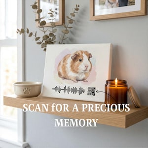 May include: A canvas print featuring a watercolor illustration of a guinea pig in shades of brown and white. The print includes a QR code and sound wave graphic. A lit candle in a glass jar and a ceramic bowl with a paw print are also visible.