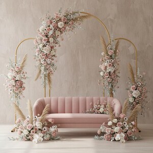 Può includere: Un divano in velluto rosa è posto di fronte a un arco dorato adornato con fiori rosa e bianchi ed erba della pampa. Ulteriori composizioni floreali circondano il divano, creando un'ambientazione romantica ed elegante.