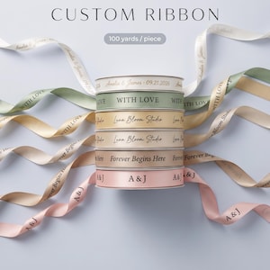 May include: A stack of six custom ribbons in white, sage green, gold, beige, tan, and light pink. Each ribbon features printed text including Amelia & James 09.21.2026, WITH LOVE, Luna Bloom Studio, Forever Begins Here, and A&J. Text reads 100 yards / piece.