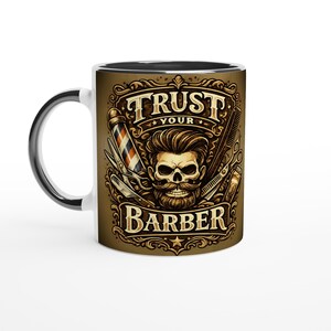 Könnte beinhalten: Weiße Keramiktasse mit schwarzem Innenraum und Griff. Die Tasse zeigt ein Friseur-Thema-Design mit einem Totenkopf, Friseurwerkzeugen und dem Text "TRUST YOUR BARBER" in einem dekorativen Rahmen. Das Design ist in Braun-, Gold- und Schwarztönen gehalten.