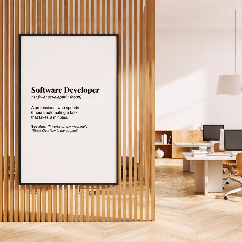 Pu&ograve; includere: Una stampa incorniciata con la definizione di "Software Developer" in testo nero. La definizione include la pronuncia fonetica, una descrizione del lavoro e frasi correlate. La stampa &egrave; esposta su una parete a doghe di legno.