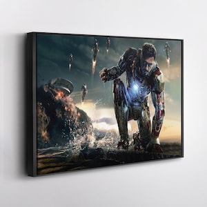 Op de afbeelding: Ingelijste kunstwerk met een knielende figuur in een metalen pak met een gloeiend borststuk, tegen een dramatische oceaan- en hemelachtergrond. Er zijn verschillende vliegende figuren zichtbaar, met een explosie in de verte.