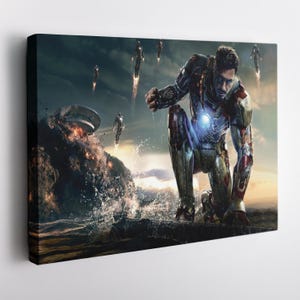 Op de afbeelding: Canvas print met Iron Man op zijn knie&euml;n, met watereffecten en andere Iron Man-figuren die op de achtergrond vliegen. Een gevechtssc&egrave;ne met explosies is zichtbaar. Het kunstwerk heeft een dramatisch, actievol thema.
