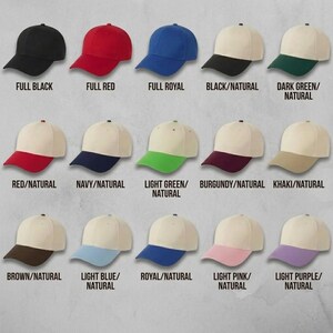 May include: Collection of baseball caps in various colors, including solid black, red, and royal blue. Other caps feature a natural-colored crown with colored brims in shades like green, navy, and pink. Each cap is labeled with its color combination.