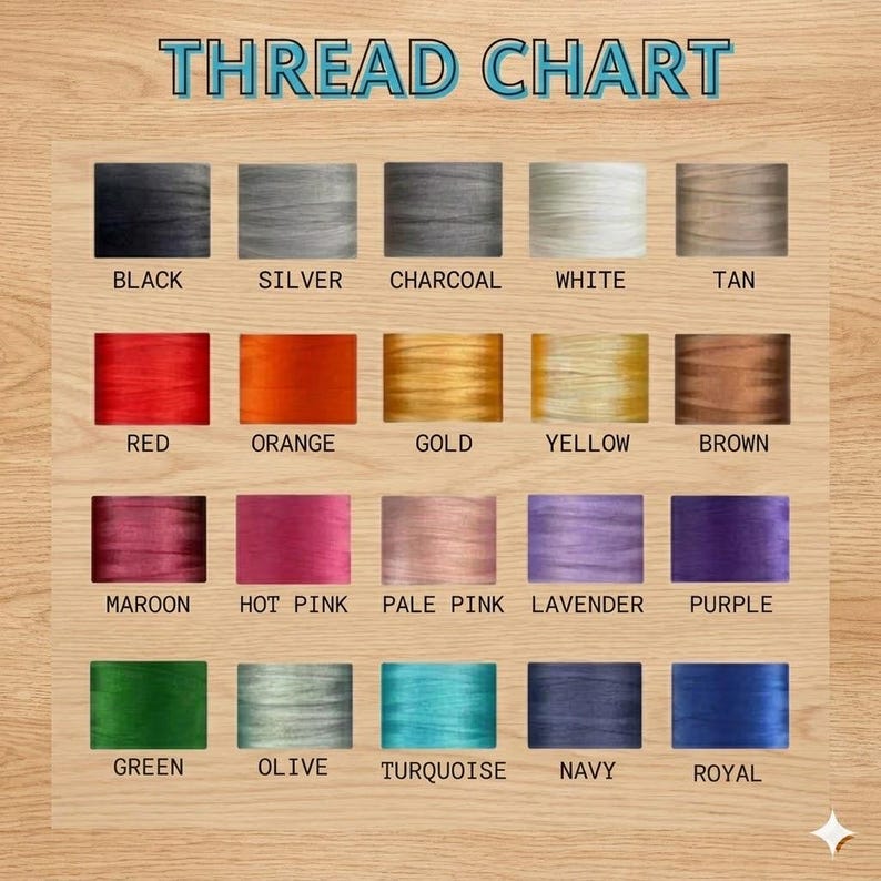 May include: A thread chart with a wooden background displays a variety of thread colors. The chart includes colors such as black, silver, charcoal, white, tan, red, orange, gold, yellow, brown, maroon, hot pink, pale pink, lavender, purple, green, olive, turquoise, navy, and royal.